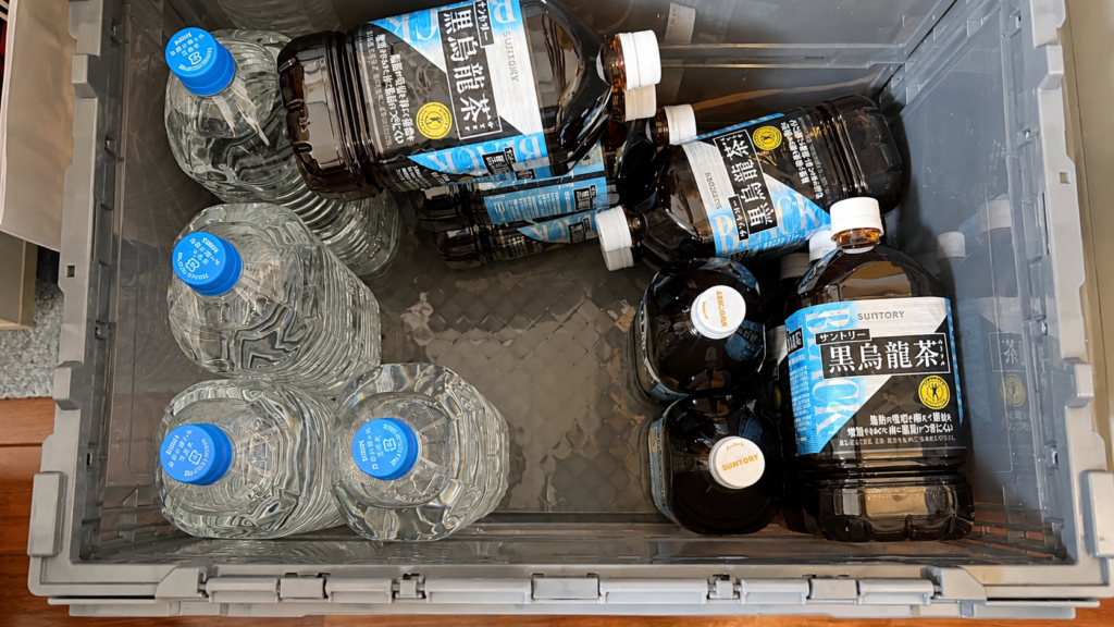 TRUSCOの50Lスケルトンコンテナに2Lの水と1.05Lの黒烏龍茶を収納した様子