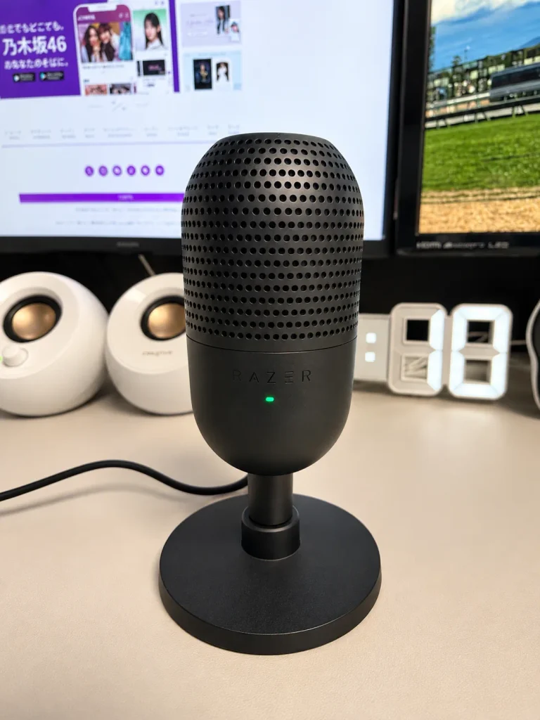 デスクに設置したRazer Seiren V3 Mini ブラック。USB接続のコンパクトなマイクで、背後にはXiaomiモニターと白いCreative Pebbleスピーカーが並んでいる。